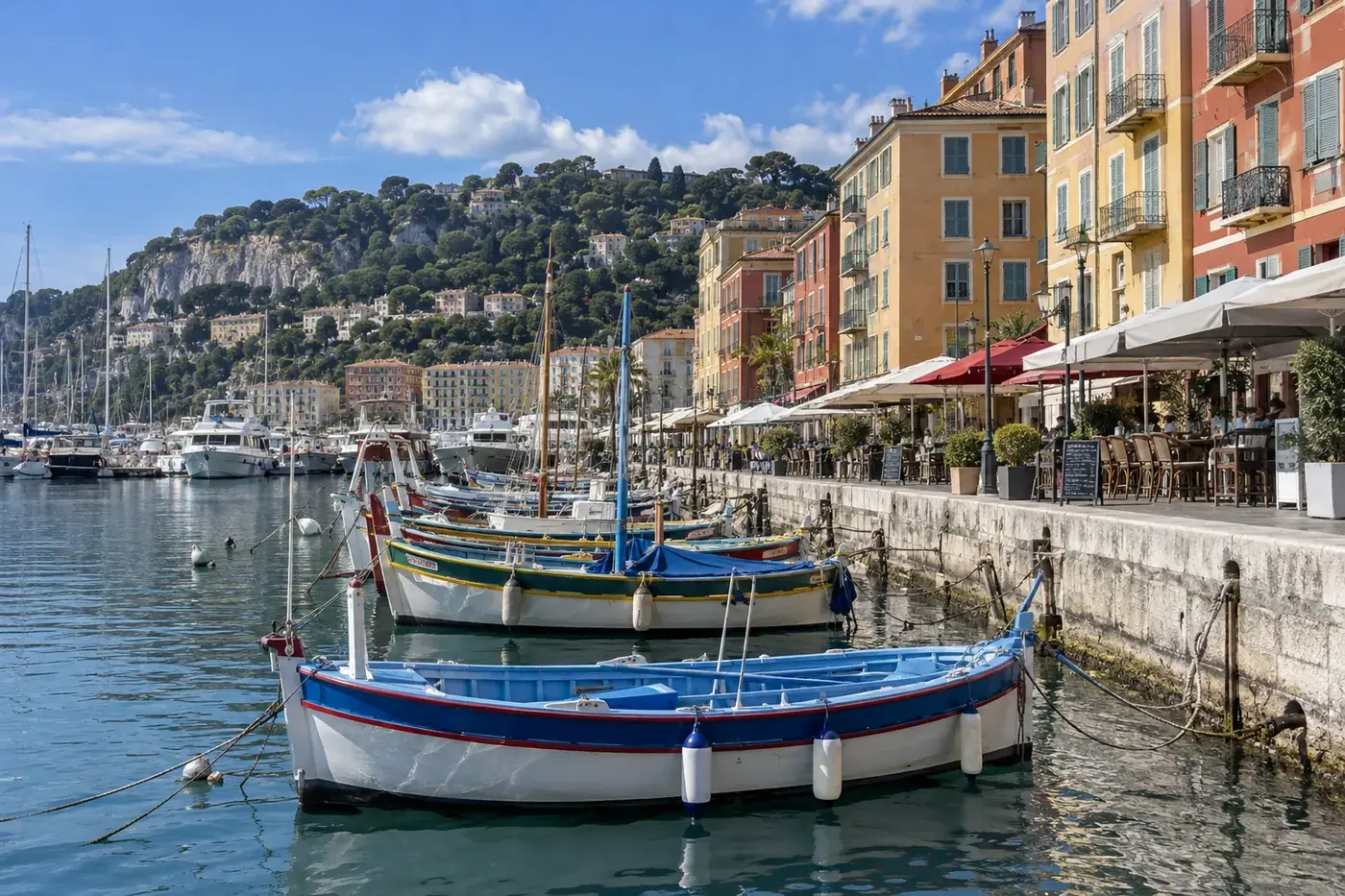 Le port Lympia à Nice, ses bateaux de pêche colorés et les terrasses alignées le long du quai